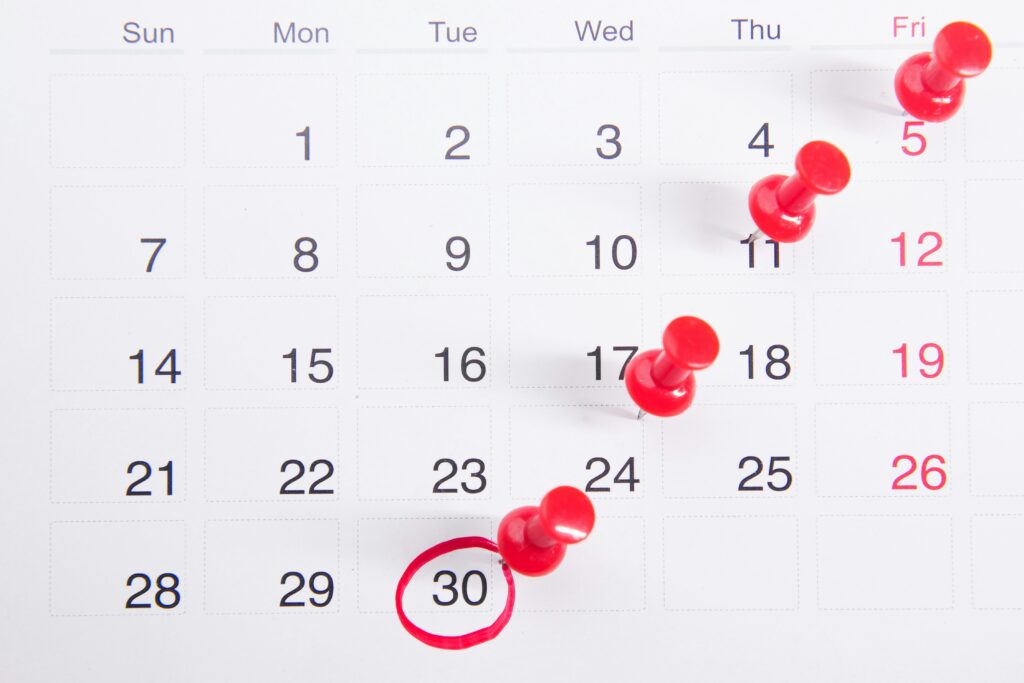 A calendar with multiple pins, with a specific date clearly circled.