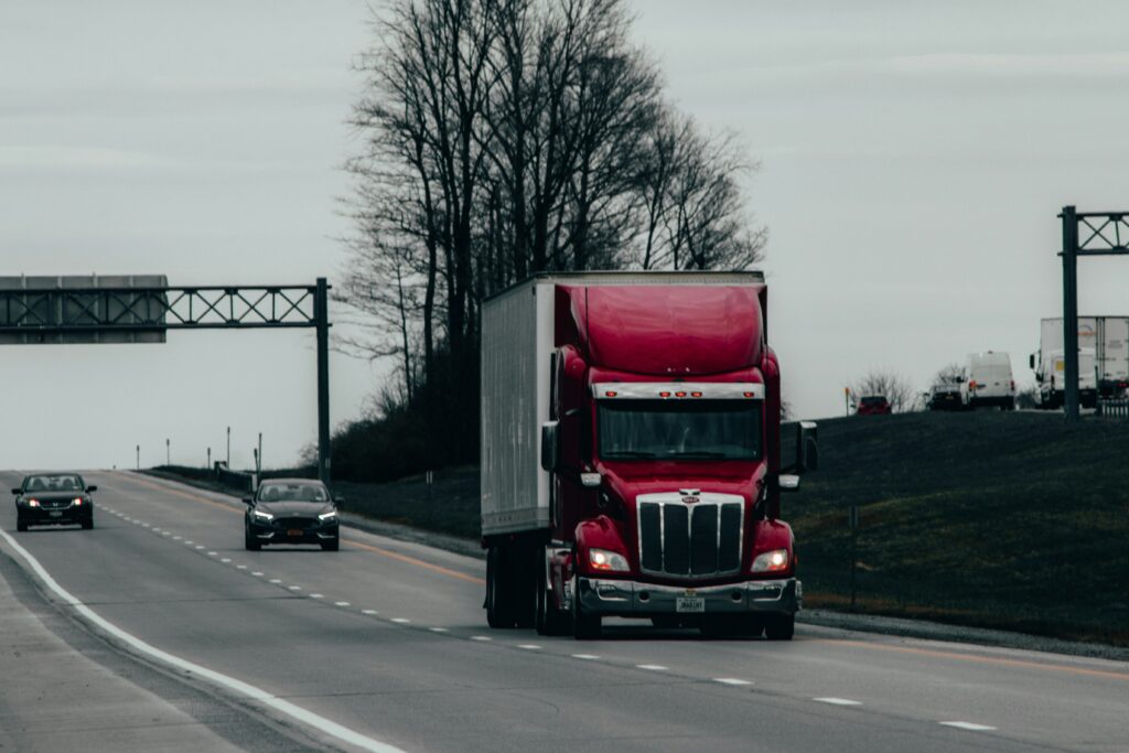 A red truck is driving on a road.
